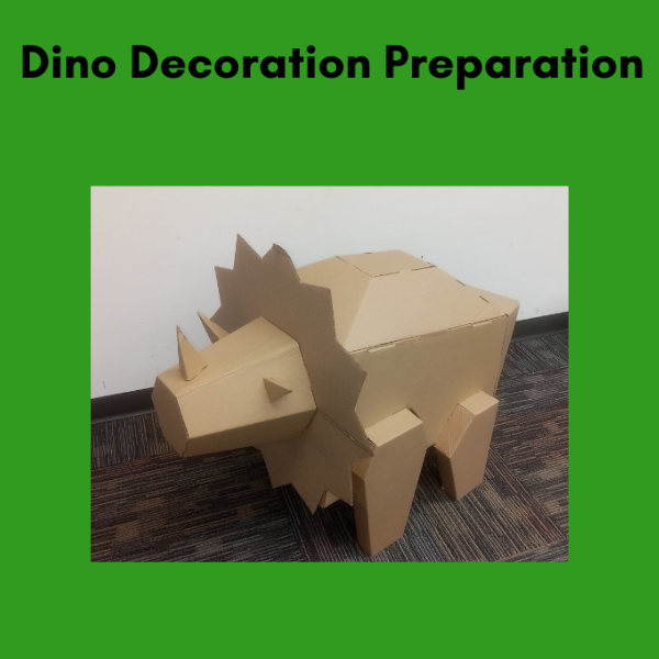 Cardboard model of a triceratops against a white wall, framed in green.